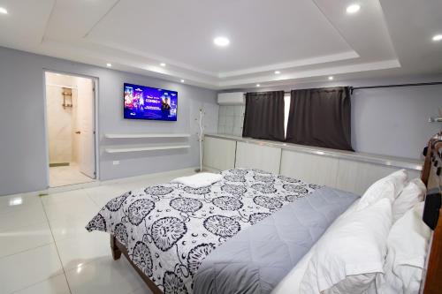 um quarto com uma cama e uma televisão de ecrã plano em Hotel Señorial em Santo Domingo