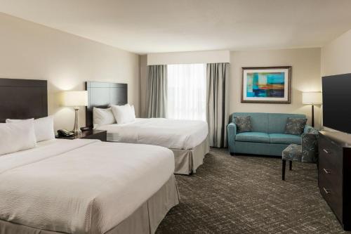 a hotel room with two beds and a blue couch at TownePlace Suites by Marriott Abilene Northeast in Abilene