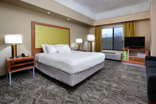 a hotel room with a bed and a flat screen tv at SpringHill Suites by Marriott Lynchburg Airport/University Area in Lynchburg