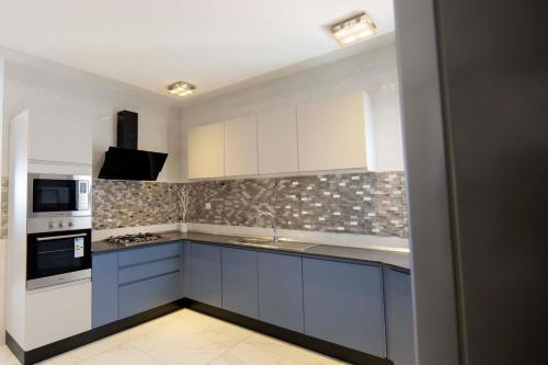 a kitchen with blue and white cabinets and appliances at RESIDENCE TERANGA immo luxe in Dakar