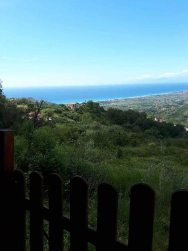 una vista del océano desde detrás de una valla en Da Maria casa con vista mare e monti, en Maierà