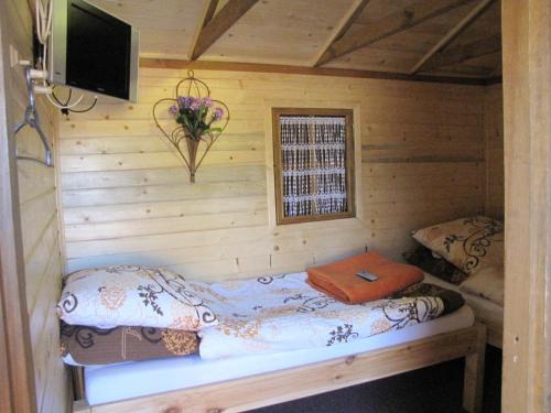 a room with a bed in a log cabin at Gościniec Grek Zorba - pokoje i domki 4 osobowe - 16km od Zator Energylandia in Inwałd
