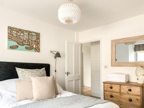 a bedroom with a bed and a mirror on the wall at The Boat Watch - 28477 in Mousehole