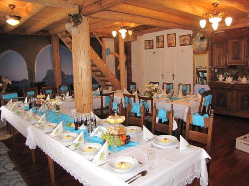 a long table with white tablecloths and food on it at Gościniec Grek Zorba - pokoje i domki 4 osobowe - 16km od Zator Energylandia in Inwałd
