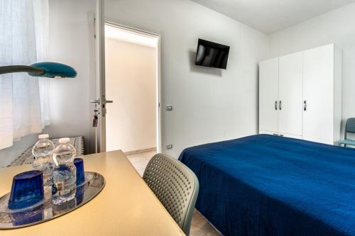 ein Schlafzimmer mit einem Bett und einem Tisch mit Brille darauf in der Unterkunft Monolocale Gio in Carbonia