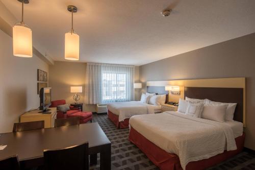 Cette chambre comprend deux lits, une table et un bureau. dans l'établissement TownePlace Suites by Marriott Provo Orem, à Orem