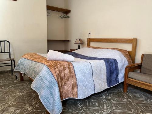 a bedroom with a bed and a chair at Tanguitos in Sucre
