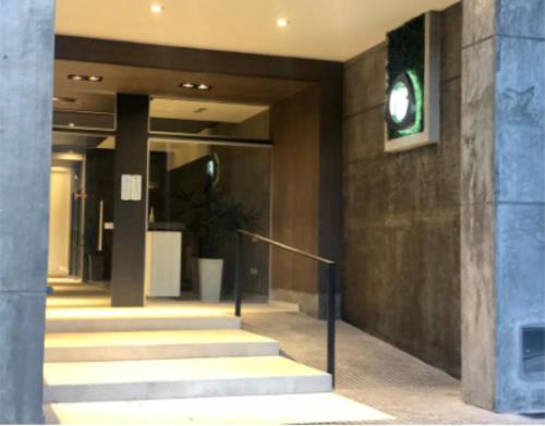a lobby of a building with stairs and a green sign at Opalo Barrio Sur A Estrenar by Citrino Aparts in San Miguel de Tucumán