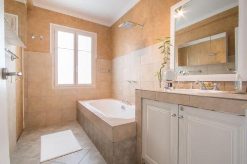 a bathroom with a tub and a sink and a bath tub at Spacieux 3 Pièces de standing au centre de Monaco in Monte Carlo