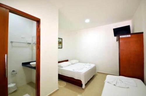 um quarto com duas camas e um espelho em Pousada do Itaguá em Ubatuba