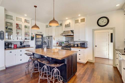 a kitchen with white cabinets and a large island with bar stools at Spacious Farmhouse Near Hikes and Waterfalls in Harrison