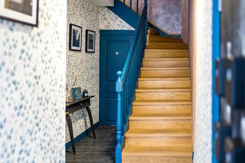 un escalier bleu dans une maison avec une porte bleue dans l'établissement Escapade Place 11 N1 - Studio Dinan centre, à Dinan