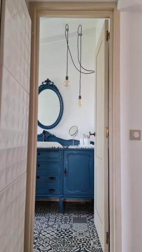 a bathroom with a blue dresser and a mirror at Monte da ti Luzia in Faro