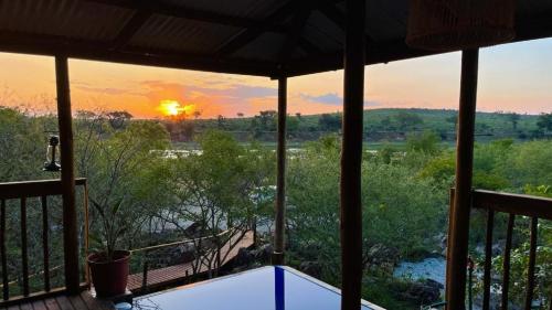 a view of the sunset from the porch of a house at Croc's Nest in Marloth Park