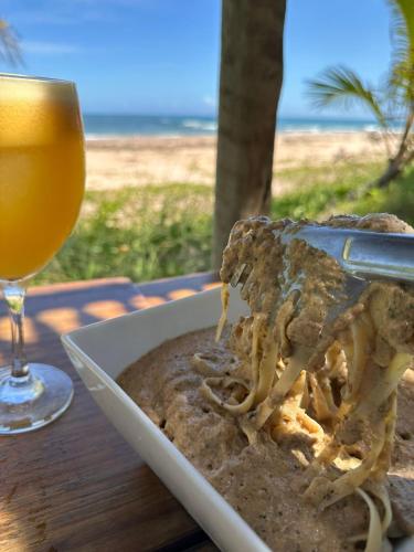 a plate of food next to a glass of beer at Casa Del Mar in Marau