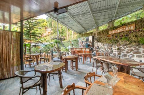 a restaurant with tables and chairs and a stone wall at Boutique Hotel Las Cascadas in Manuel Antonio