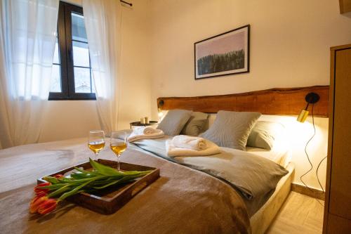 a bedroom with a bed with two glasses of wine at Apartman TALIJA in Pirot
