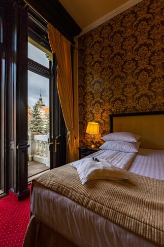 a bedroom with a bed and a window with a view at Hotel Central Park Sighisoara in Sighişoara