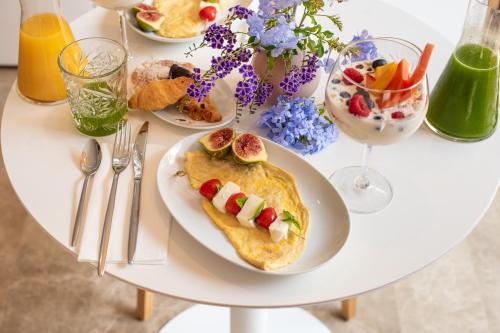 a white table with a plate of food on it at Agroturismo Safragell Ibiza Suites & Spa in Sant Llorenç de Balafia