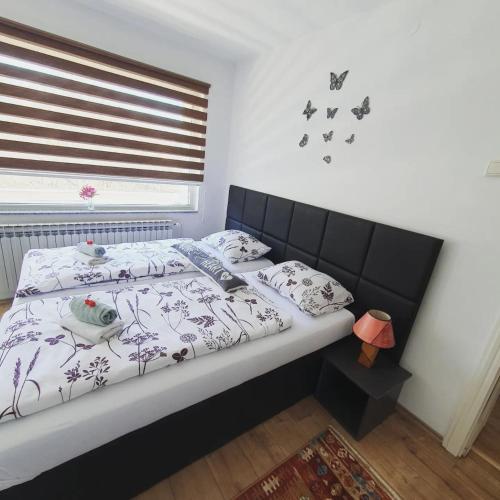 a bedroom with a bed with butterflies on the wall at Apartments Arna in Visoko