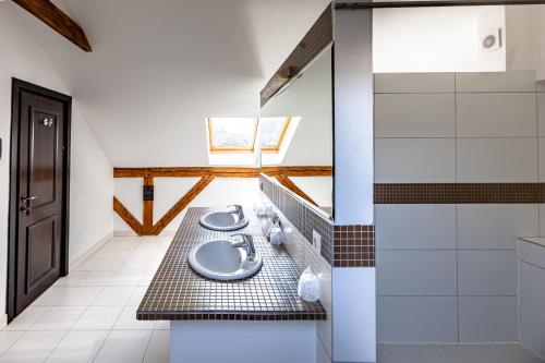 a bathroom with two sinks and a toilet in it at Hotel Central Park Sighisoara in Sighişoara