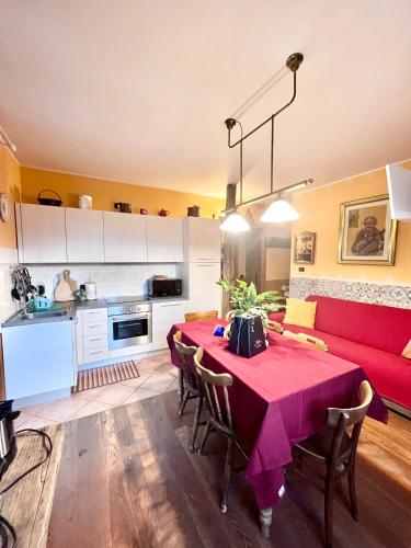 a living room with a table and a red couch at Casa Unica- da Bruno in Colico