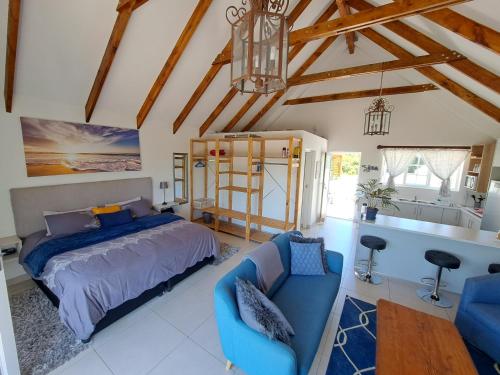 a bedroom with a blue bed and a kitchen at Cape Dutch Flair in Durbanville