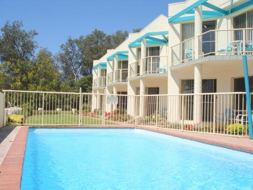a house with a swimming pool in front of a house at Bayview Apartments in Merimbula
