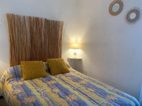 - un lit avec 2 oreillers jaunes dans une chambre dans l'établissement Studio Balaruc-les-Bains, 1 pièce, 4 personnes - FR-1-503-7, à Balaruc-les-Bains