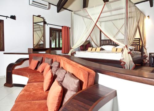 a hotel room with two beds and a couch at Ravintsara Wellness Hotel in Ambaro