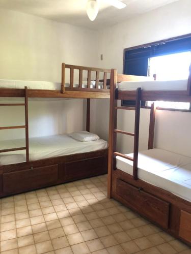 a room with three bunk beds in a room at Get Up Hostel in Natal