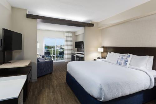 オーシャンシティにあるFairfield Inn & Suites by Marriott Ocean Cityの大型ベッドとテレビが備わるホテルルームです。