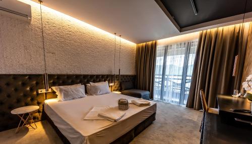 een hotelkamer met een bed en een groot raam bij Rocca Resort in Glavatartsi