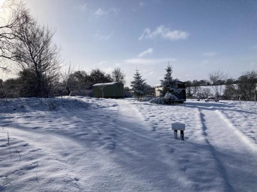 a field covered in snow with a object in it at The Shepherd's Hut with cozy logburner in Wrexham