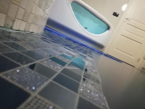 a bathroom with a toilet with a blue floor at B&b kabbala club in Lattarico