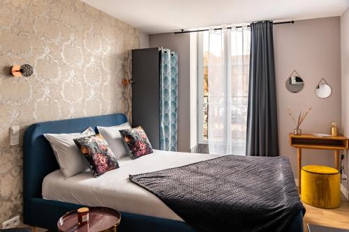 ein Schlafzimmer mit einem blauen Bett und einem Fenster in der Unterkunft Escapade Place 11 - N2 Studio - Dinan centre in Dinan