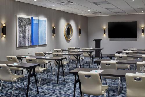 a conference room with tables and chairs and a screen at Le Méridien St. Louis Clayton in Clayton