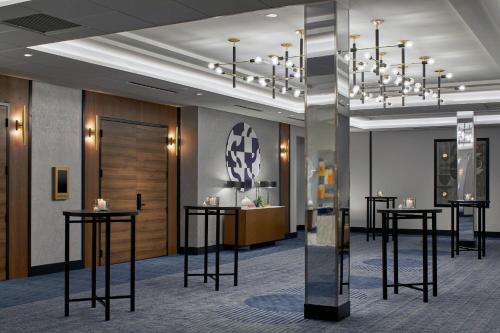 a lobby with black tables and a chandelier at Le Méridien St. Louis Clayton in Clayton