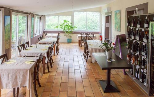 - un restaurant avec des tables, des chaises et des bouteilles de vin dans l'établissement Auberge De La Vallee, à Saint-Jean-de-Buèges