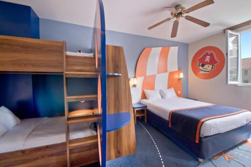 a bedroom with two beds and a bunk bed at Explorers Hotel Marne-la-Vallée in Magny-le-Hongre