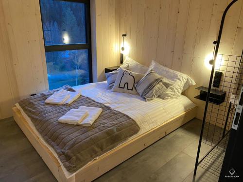 sypialnia z łóżkiem z ręcznikami i oknem w obiekcie Widokownia Brenna w Brennie