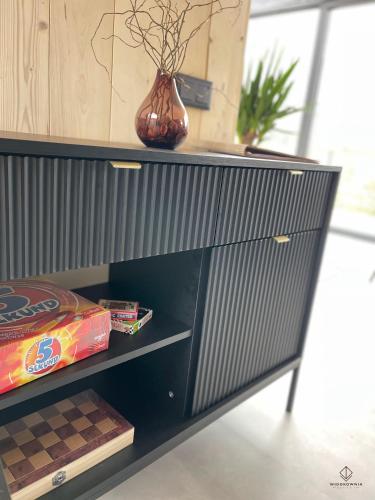 a black cabinet with a vase on top of it at Widokownia Brenna in Brenna