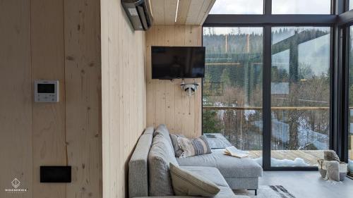 a living room with a couch and a flat screen tv at Widokownia Brenna in Brenna