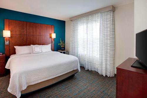 a bedroom with a large bed and a large window at Residence Inn Chicago Midway Airport in Bedford Park