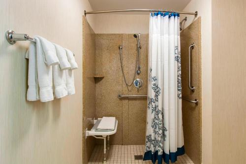 a bathroom with a shower and a toilet and towels at Residence Inn Chicago Midway Airport in Bedford Park