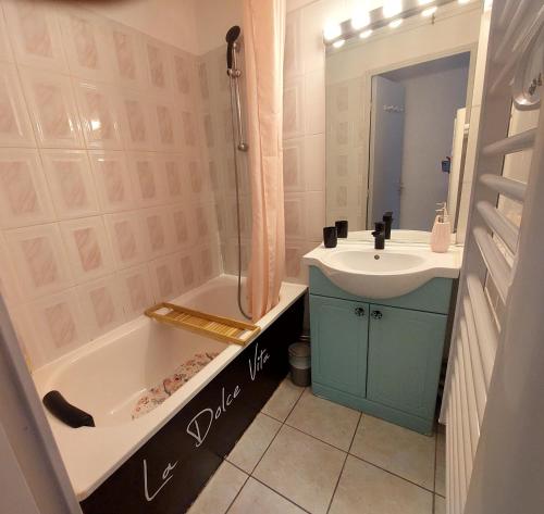 een badkamer met een bad, een wastafel en een douche bij Appart A l'abordage Sète, Gare, parking in Sète