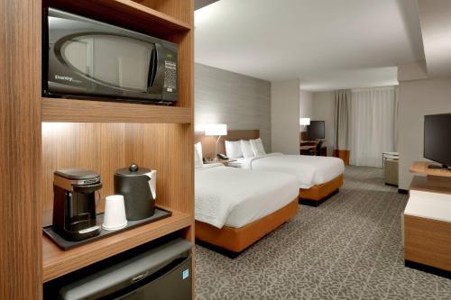 a hotel room with two beds and a flat screen tv at Fairfield Inn & Suites by Marriott Springfield North in Springfield
