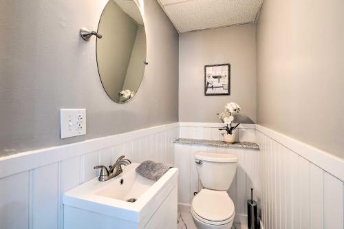 a bathroom with a sink and a toilet and a mirror at Dog-Friendly Downtown Auburn Vacation Rental! in Auburn