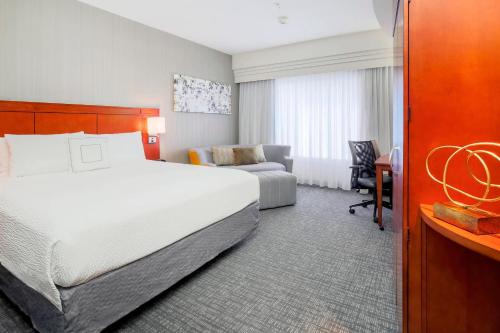 a hotel room with a large bed and a desk at Courtyard by Marriott Dallas Arlington South in Arlington