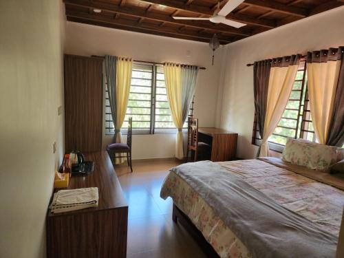 een slaapkamer met een groot bed en 2 ramen bij VanaJyotsna Forest Home in Maraiyūr